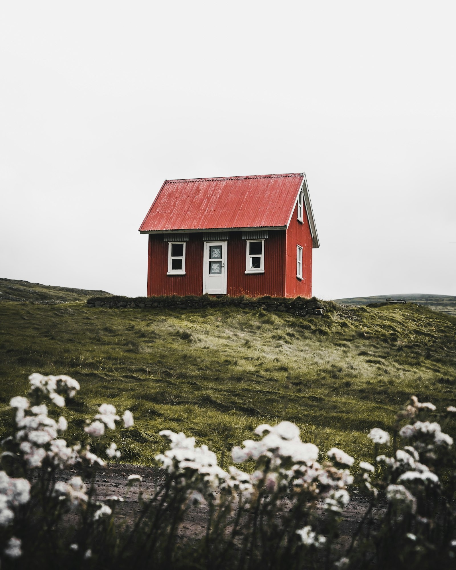 Restored high-country cabin on a tussock hillside — the original Actionofferway lodge