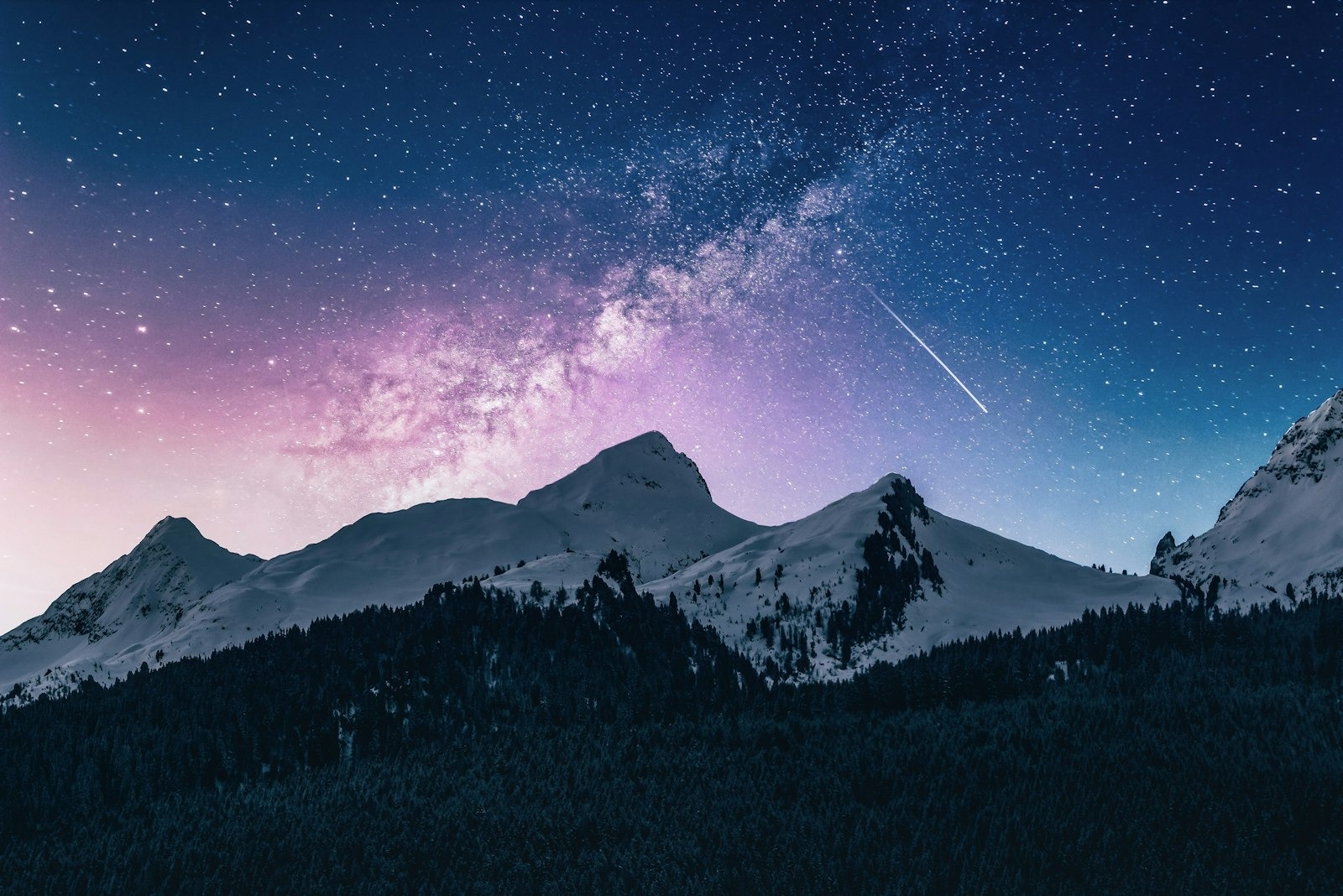Star field and Milky Way arcing over snow-capped Southern Alps peaks