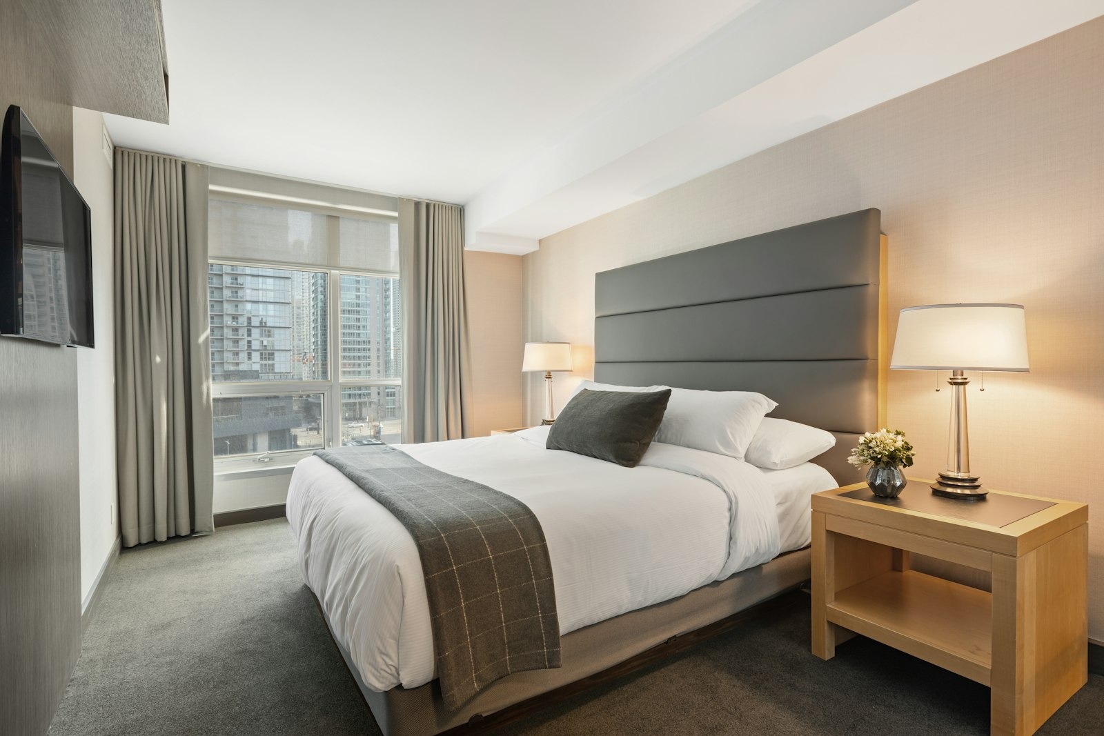 Standard room — queen bed, warm timber headboard, reading lamps