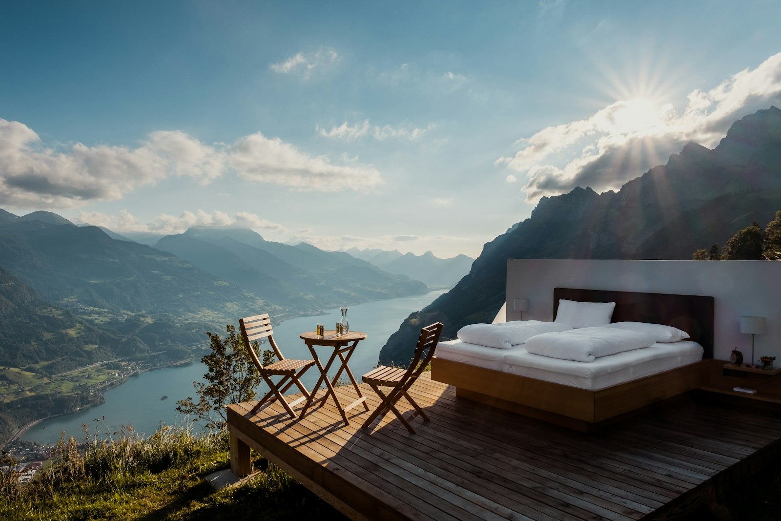 Luxury suite — private open-air deck with bed overlooking the alpine lake