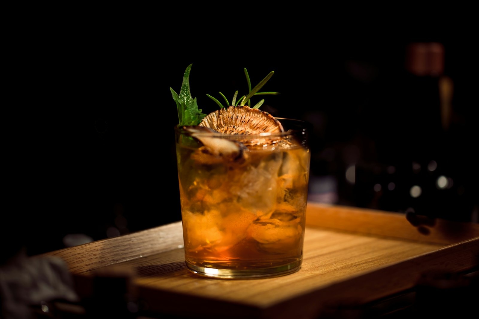 Amber whisky cocktail in cut crystal on a dark bar, Salon Noir